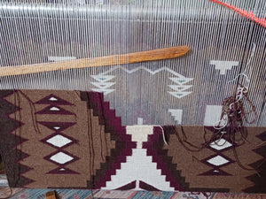 Weaving loom with a partially completed Navajo rug.