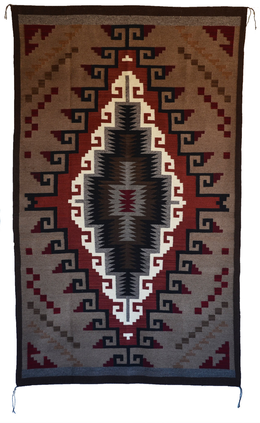 Navajo-style woven rug with geometric pattern on a plain background